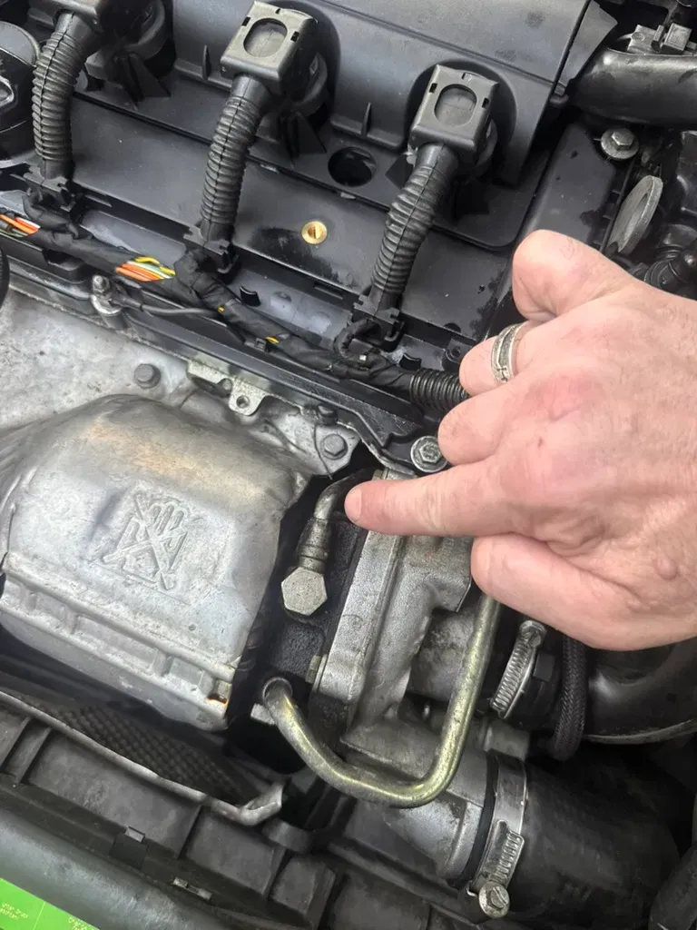 Technician inspecting a turbocharger oil feed line